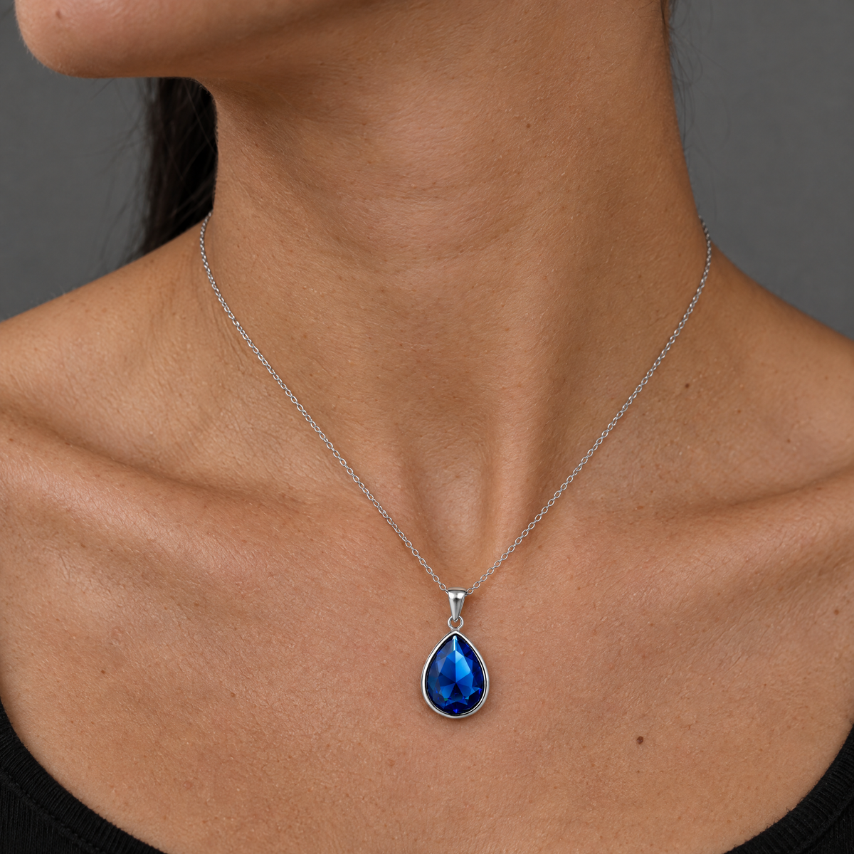 Collar Enara de plata 925 puesto, colgante gota azul sobre el cuello