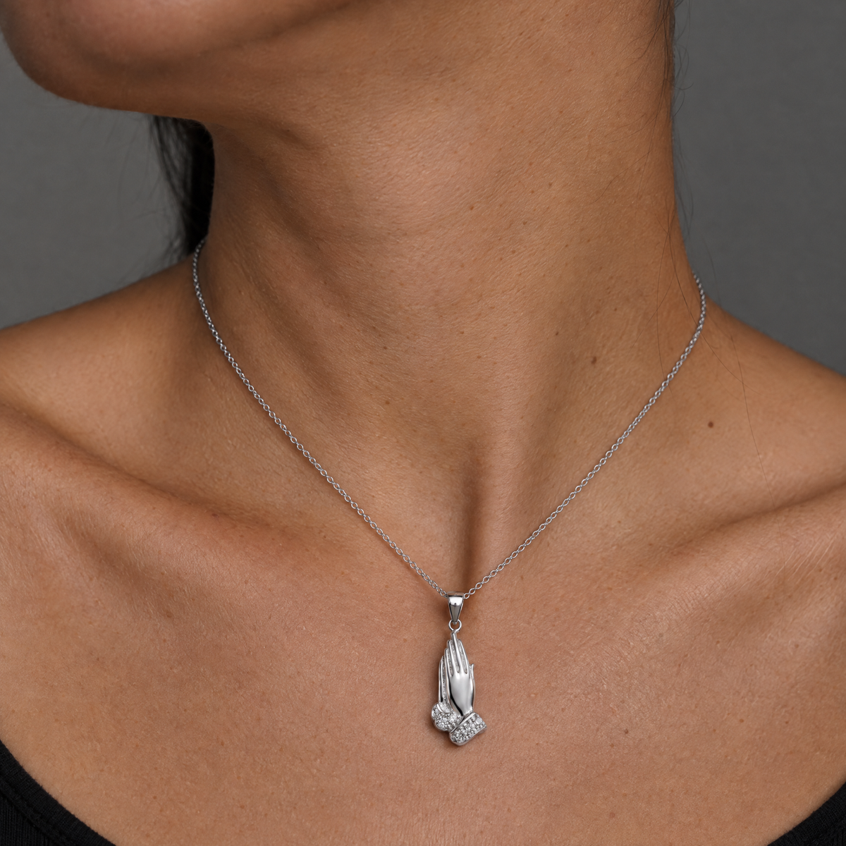 Collar Erya de plata 925 puesto, colgante de manos en oracion sobre el cuello