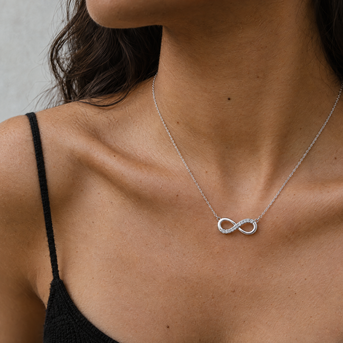 Mujer con top negro luciendo el colgante Selia de plata 925